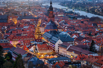 Fototapeta premium Panoramic, elevated view of the festive decorated old town of Heidelberg, Germany, around the Heiliggeistkirche during winter dusk