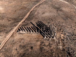 Aerial drone view of the sculpture Presence featuring 24 basalt columns with long shadows at the...