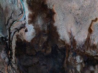 Aerial view of unique black and white textured terrain with a blue river, Turkey