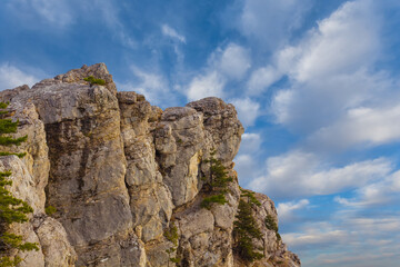 mountain cliff on the blue cloudy sky background