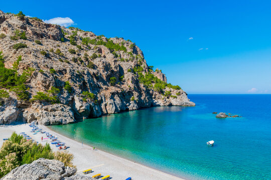 Panoramic view of white pebbled Achata beach with turquoise sea, surrounded by mountains on Karpathos island, Greece