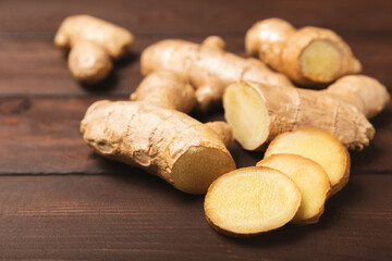 Fresh ginger on wooden background. Dry ginger. Sliced ​​ginger with honey and lemon. Ginger...