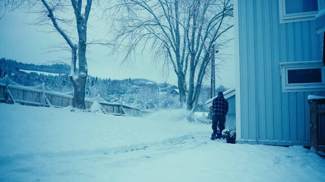 A Man Using Snow-Blowing Shovel During Winter. Static Shot