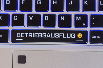 Betriebsausflug Symbolbild: Tastatur mit der Aufschrift BETRIEBSAUSFLUG, daneben ein fröhlicher...