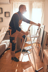 Carpenter working and assembling furniture in a new apartment.