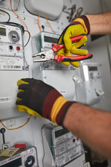Technician working on a modern electricity power meter station in a building.