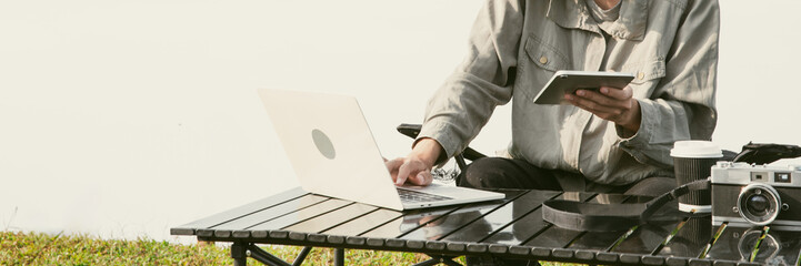 Young business man working computer on peak hill. Hiker online shopping on laptop at sunset, sunrise on top mountain, freelance person remote work with digital tablet. travel vacation holiday concept