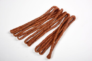 Kabanos dried sausages on white background. Polish thin, long, dry sausage