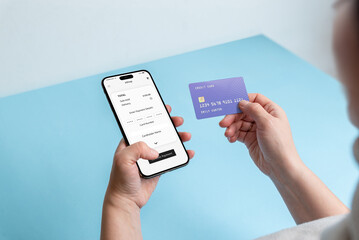 Young woman entering credit card details on a smartphone for online shopping, illustrating the concept of digital and secure e-commerce transactions