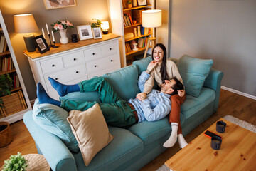 Obraz premium Beautiful young couple cuddling and relaxing at home