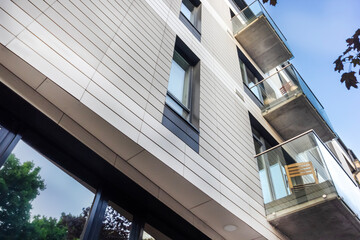 Minimalistic building with a white facade, glass balconies in Europe