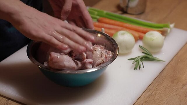 cook marinates chicken legs in close-up, mixes marinade with his hands