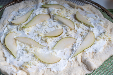 Pizza textured background with pear and gorgonzola and parmesan cheese. Raw pizza in a curly plan.