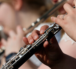 Musicians playing wooden wind instruments at a performance in a park during a sunny afternoon