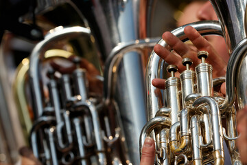 Obraz premium Musicians perform with tubas during an outdoor concert in a park on a sunny afternoon