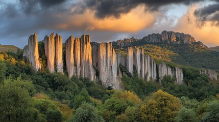Fototapeta premium The warm hues of sunrise casting a golden sheen over jagged mountain cliffs.