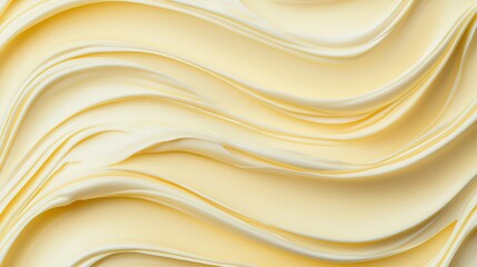 A smooth, wavy texture of creamy butter with a soft golden hue, evoking a sense of richness and indulgence.