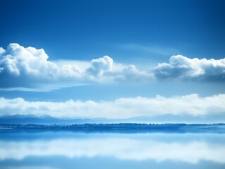 Serene lake reflecting blue sky and clouds.