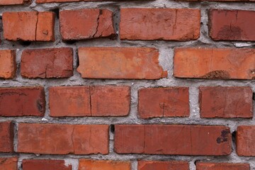 Red brick wall texture background. Brick wall with scratches and cracks. Background of old brick wall.