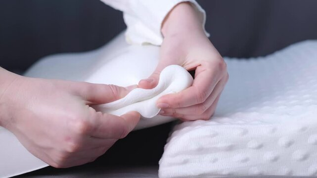 Woman squeezing a polyurethane pillow, demonstrating its memory foam ability to mold to body shape and relax muscles.