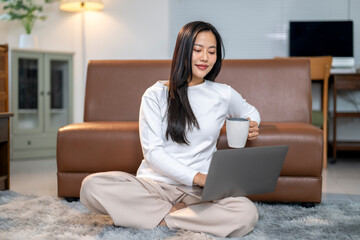 Naklejka premium A woman is sitting on the floor in a living room, holding a cup