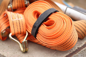 Lashing straps. Trailer strap made of orange nylon and metal tie. Close-up of a load holding strap....