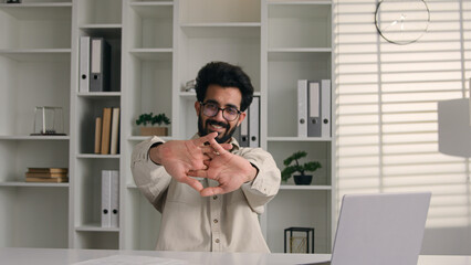 Tired Arabian businessman Indian muslim man working remote happy satisfied male guy sit at office...