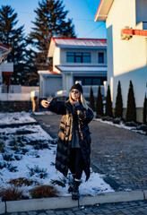 Woman selfies in snowy area. A woman dressed in a black puffer coat and sunglasses takes a selfie...