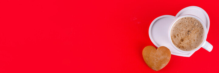 Valentines Day background with cozy sweet romantic atmosphere, candy chocolates, cookie, freshly brewed cup of coffee latte on heart-shaped plate, top view copy space