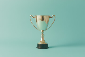 Fototapeta premium Silver Trophy on Teal: A gleaming silver trophy, complete with two handles and a black base, stands majestically against a serene teal backdrop.