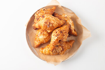 Freshly baked croissants with almonds on a plate