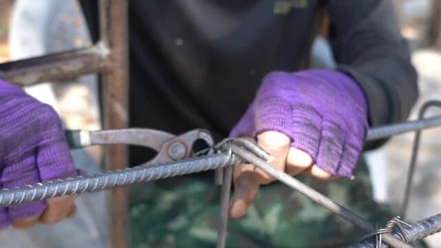 The hands of construction workers using using steel wire to bind steel bars Construction concept