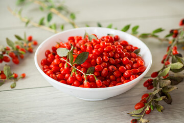 fresh ripe red goji berries in a bowl on a wooden table