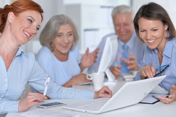 happy businesswomen and businessman working in office