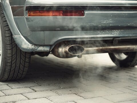 Old Combustion Engine Car Exhaust With White Smoke Emissions in Urban Environment