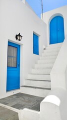 The cute white and blue buildings and old doors and arches in a small greek village