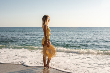 Gorgeous fashion model in swimsuit on a sand beach. Summer holiday concept.
