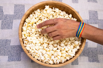 LGTBI person taking popcorn from a bowl