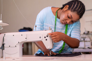 tailor working on a sewing machine, stitching fabric together at the shop