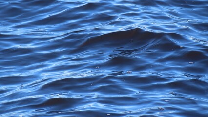 Close up of rolling waves on blue river water surface, natural background