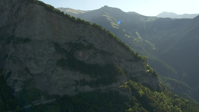 Vol panoramique d'une montagne, for&ecirc;t et d&eacute;couverte des montagnes et d'une prairie