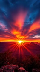 Obraz premium A stunning sunset casts vibrant colors across the sky, illuminating the landscape with rays of golden light.