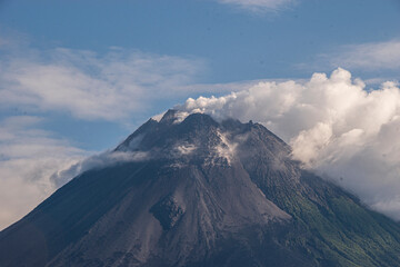 The smoking peak of Mount Merapi, the most active stratovolcano in Indonesia and has erupted...