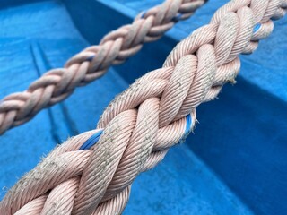 Fototapeta premium Close-Up of Nautical Rope On Blue Background With Focus on Details