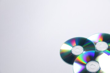 Many shiny compact discs on light background. Space for text