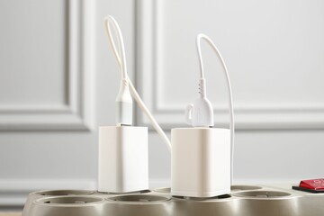 USB adapters with charge cables in power strip, closeup