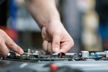 Close-up of technician repairing TV circuit board with precision