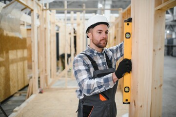 Portrait of a carpenter smiling with crossed arms in a lumber warehouse, showcasing expertise in...