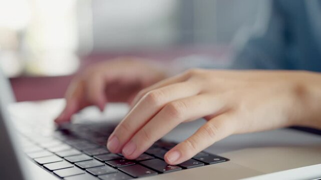 A person is typing on a laptop with their hand on the keyboard. Concept of productivity and focus, as the person is likely working on a task or project. The laptop itself is a modern and sleek device