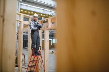 A carpenter works on the construction of modular houses